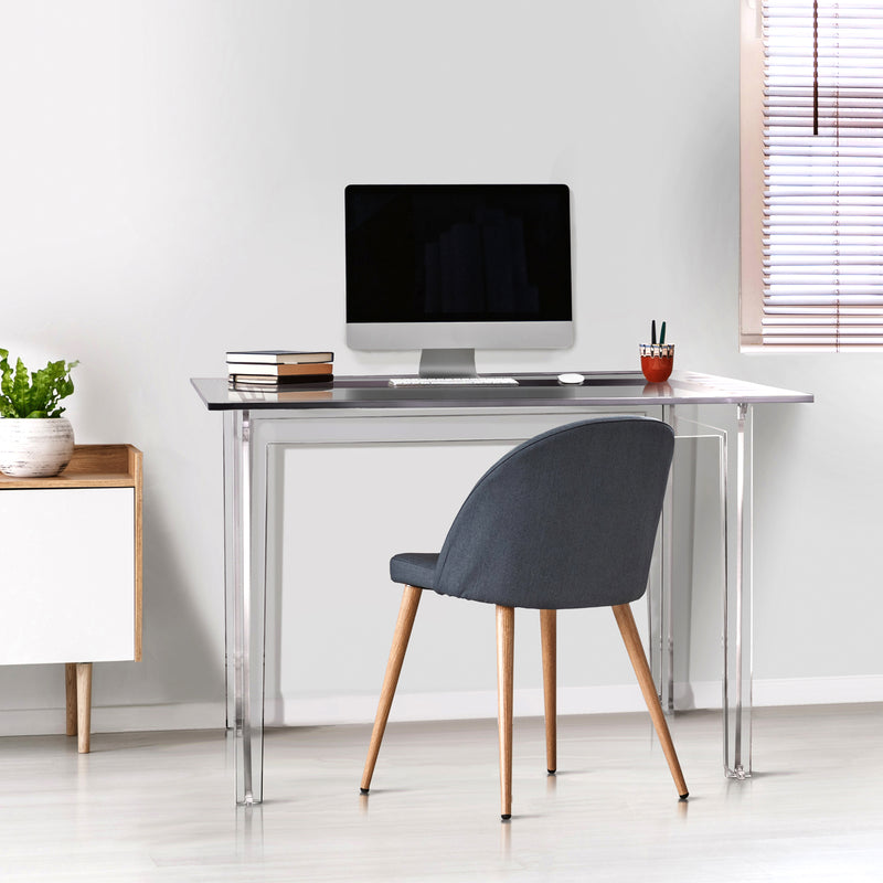 imac computer in clear acrylic desk with white walls and window